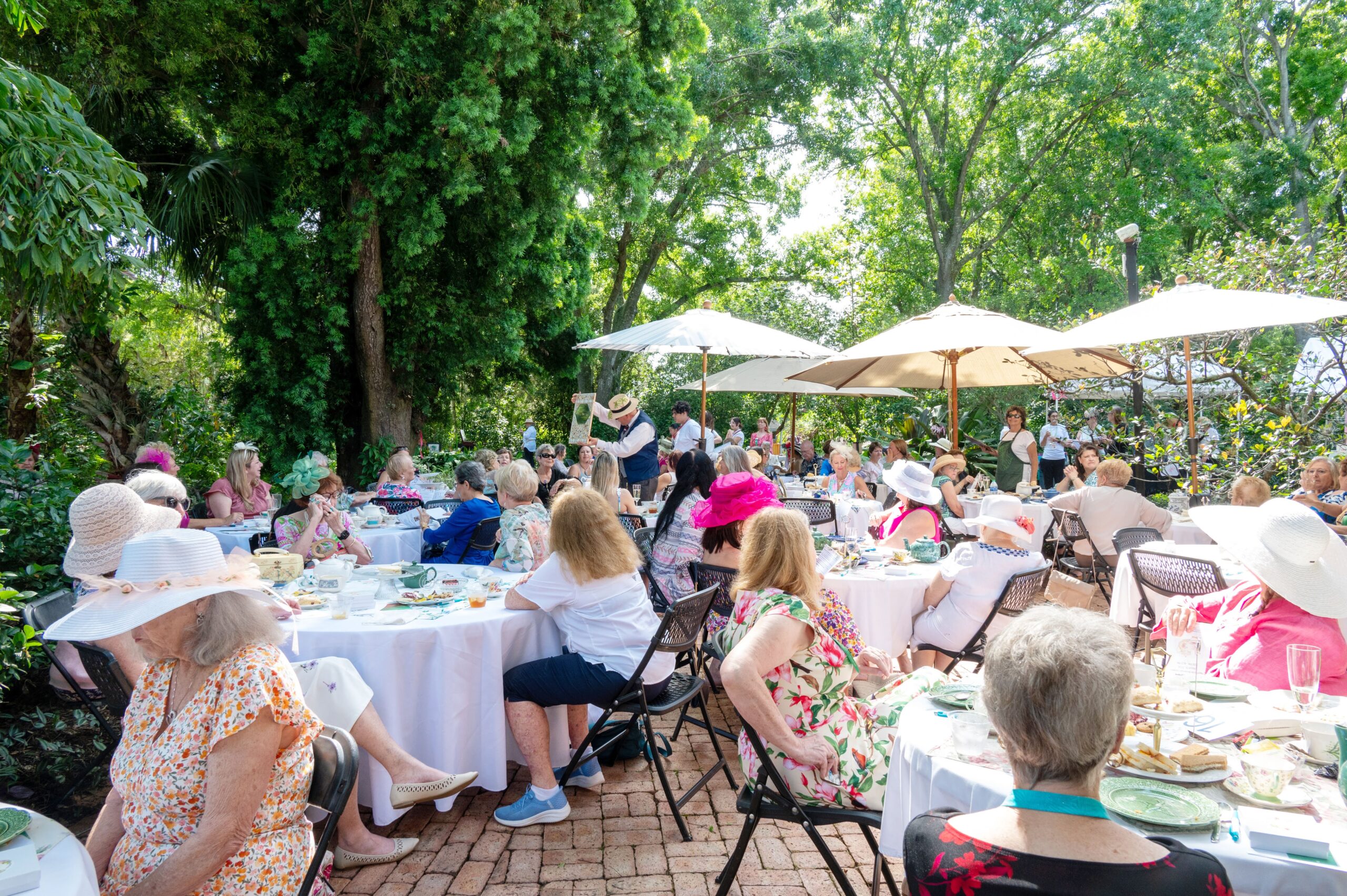 attandees on patio biddng on live auction item TIG 2024